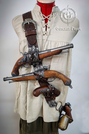 Mannequin wearing a historical outfit with a crossbow and pistols, branded 'Outcast Props'. Pirate baldric for 4 flintlock pistols and a sword, inspired by Blackbeard, Anne Bonny, Captain Kidd and Pirates of the Caribbean. Ideal for LARP, Renfaire, renaissance fair, Pirate Weekend, cosplay, Halloween and Black Sails. Silver-engraved leather, handmade with vegetable-tanned leather. Premium pirate shoulder belt for Jack Sparrow costume, historical reenactment and fantasy events. High quality pirate accessory