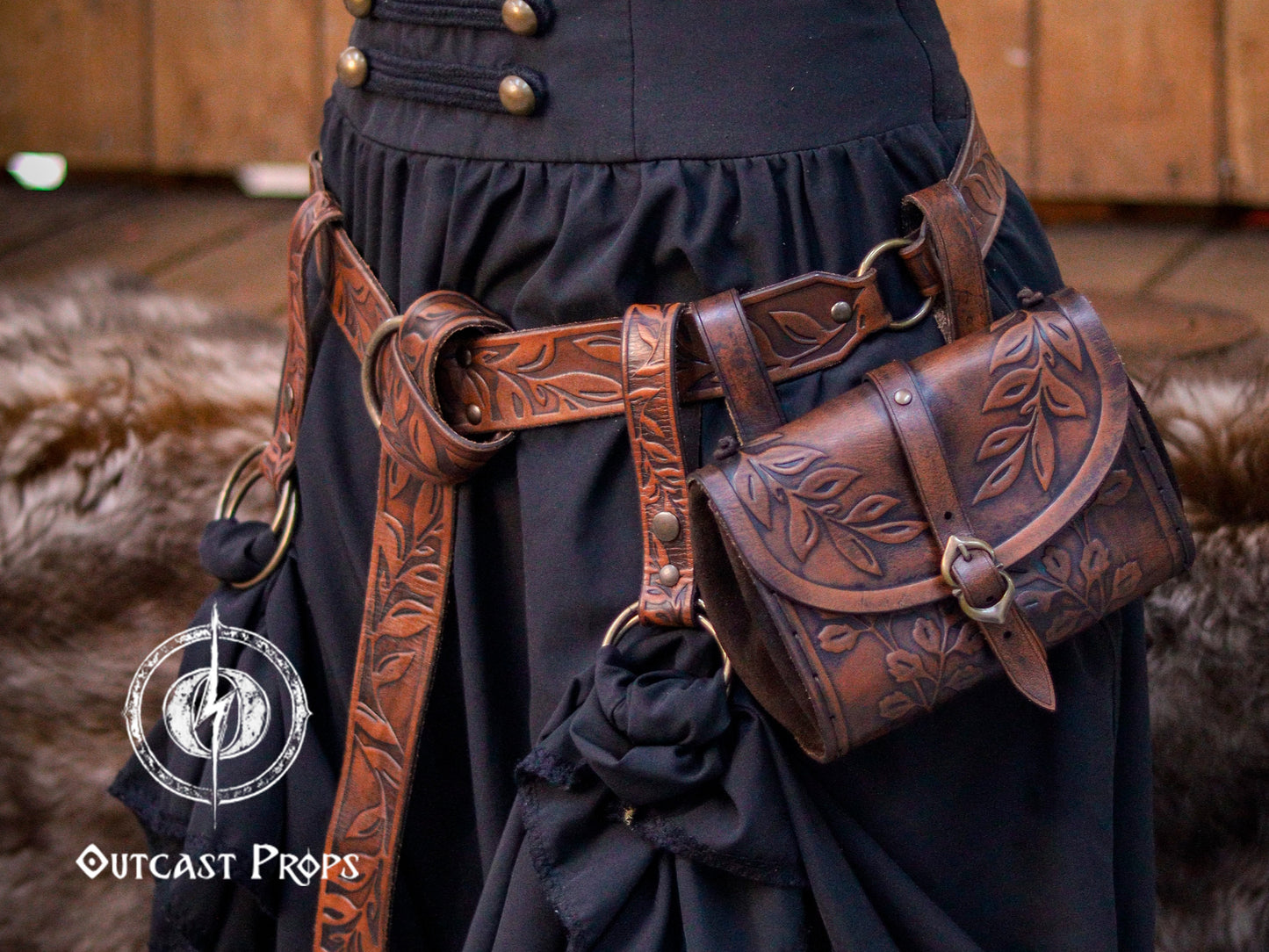 Adventure-ready leather set featuring a floral tooled belt with O-rings, a matching hip bag, and skirt hikes, worn over a fantasy outfit. Crafted from premium vegetable-tanned leather and aged by hand, perfect for LARP heroes, fantasy adventurers, witches, and Ren Faire wanderers. Designed for carrying potions, maps, and treasures, blending practicality with the timeless style of epic quests and medieval tales.