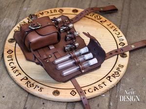Angled view of the brown leather leg holster partially open, revealing three glass potion vials with cork stoppers inside handmade holders. A large pouch with brass buckle provides extra storage. Crafted by Outcast Props from full-grain vegetable-tanned leather, this fantasy potion holster is ideal for LARP, cosplay, and renaissance fair costumes, offering realistic medieval design, versatility, and durable artisan quality.