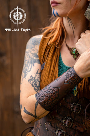Person wearing detailed arm armor with 'Outcast Props' branding. Shadowbinder bracer for mages & wizards, sorcerer vambarce for larp costume and wizardry cosplay leather witchcraft handmade