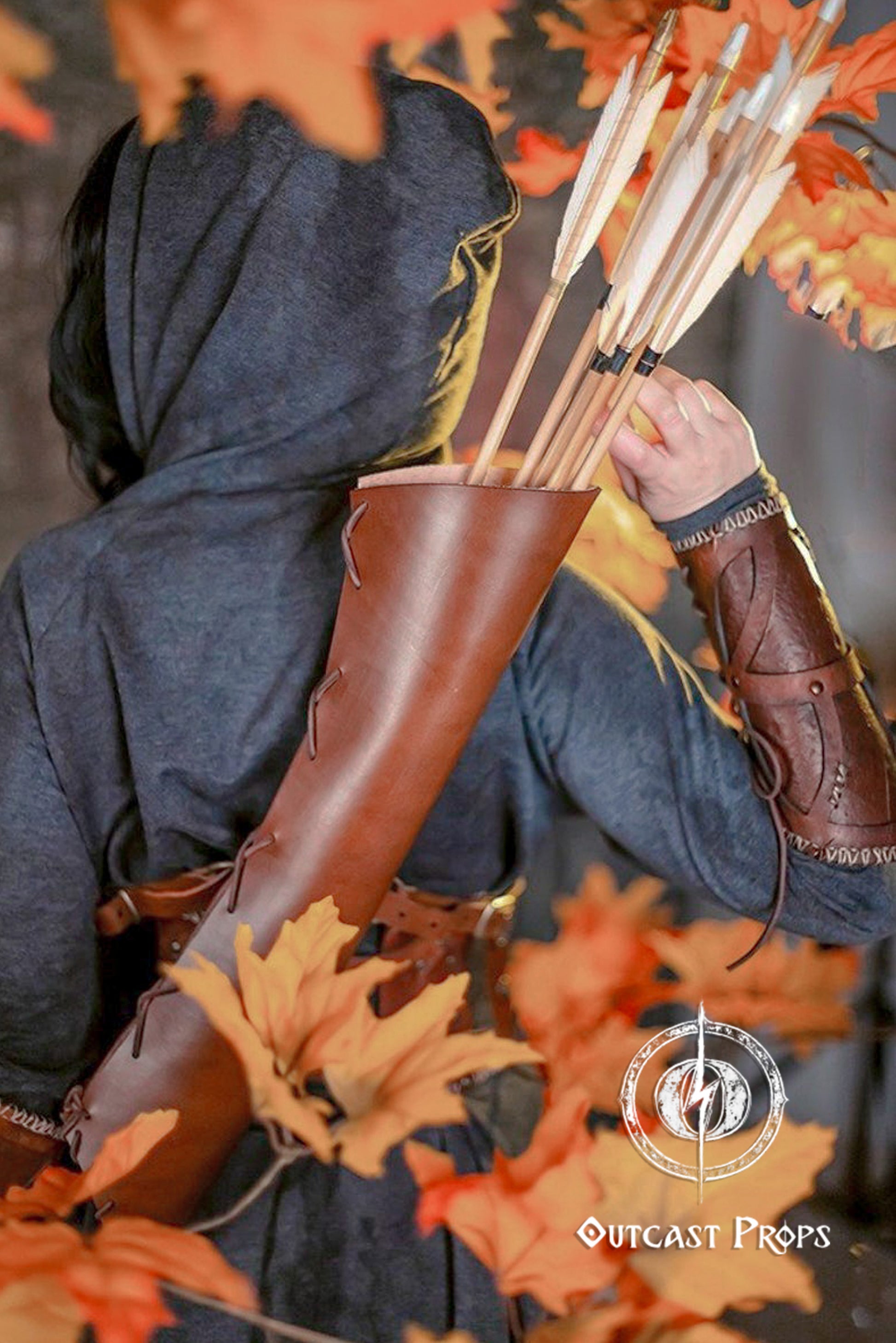 Fantasy archer drawing an arrow from a leather quiver strapped across their back. Surrounded by autumn leaves, the image evokes scenes from fantasy roleplay, perfect for a larp quiver character. The brown leather arrow quiver stands out clearly, offering an immersive touch to elf armor, cosplay or archery quiver gear. Made for roleplayers and reenactors.