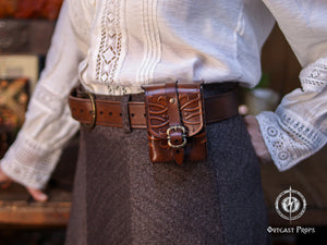 Ornated leather tobacco bag worn on a belt, crafted from premium vegetable-tanned leather with embossed fantasy motifs and brass buckle. This medieval belt pouch is designed for daily wear, holding cards, tobacco, coins, or small essentials. Ideal as a handmade leather gift, LARP accessory, Renaissance fair pouch, or stylish fantasy-inspired everyday bag.
