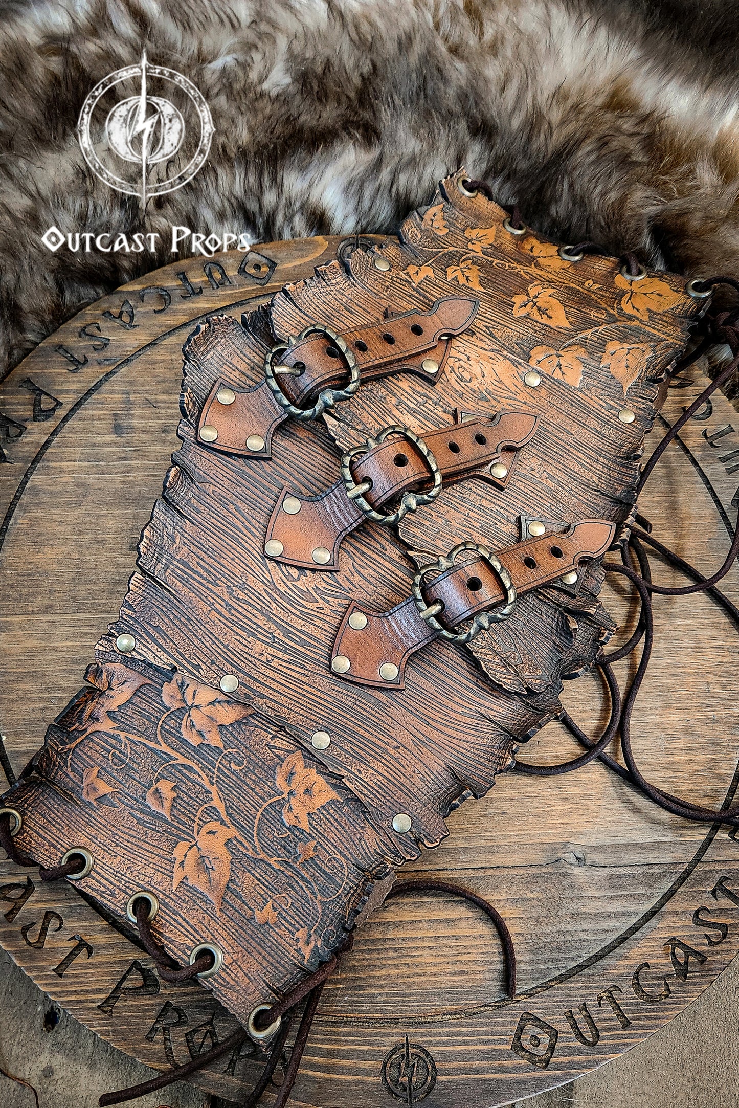 Wooden belt with leather straps on a fur background, featuring 'Outcast Props' branding. Underbust Wood Leather Corset. Herbalist corset. Druid corset. Elven Corset. Ivy Corset.