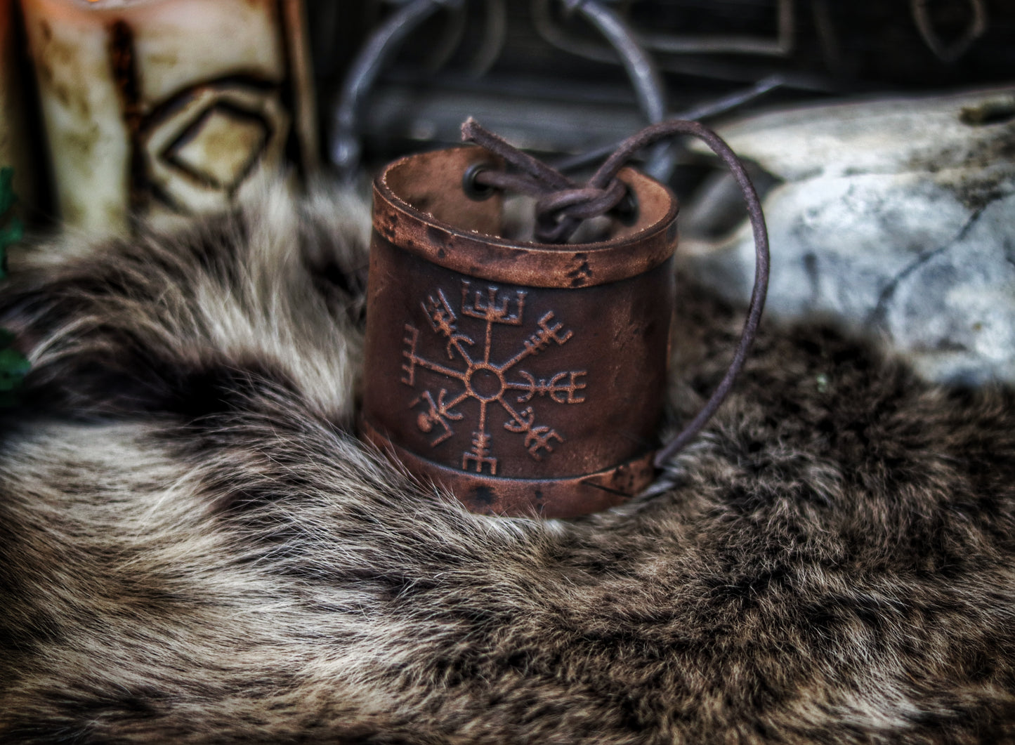 A brown leather wristband with a Viking compass design, displayed on a furry surface, featuring intricate handcrafted details. Vegvisir Leather Wristband, Galdrastafir Viking Bracelet, Icelandic way finder rune leather embossed cuff, LARP, cosplay