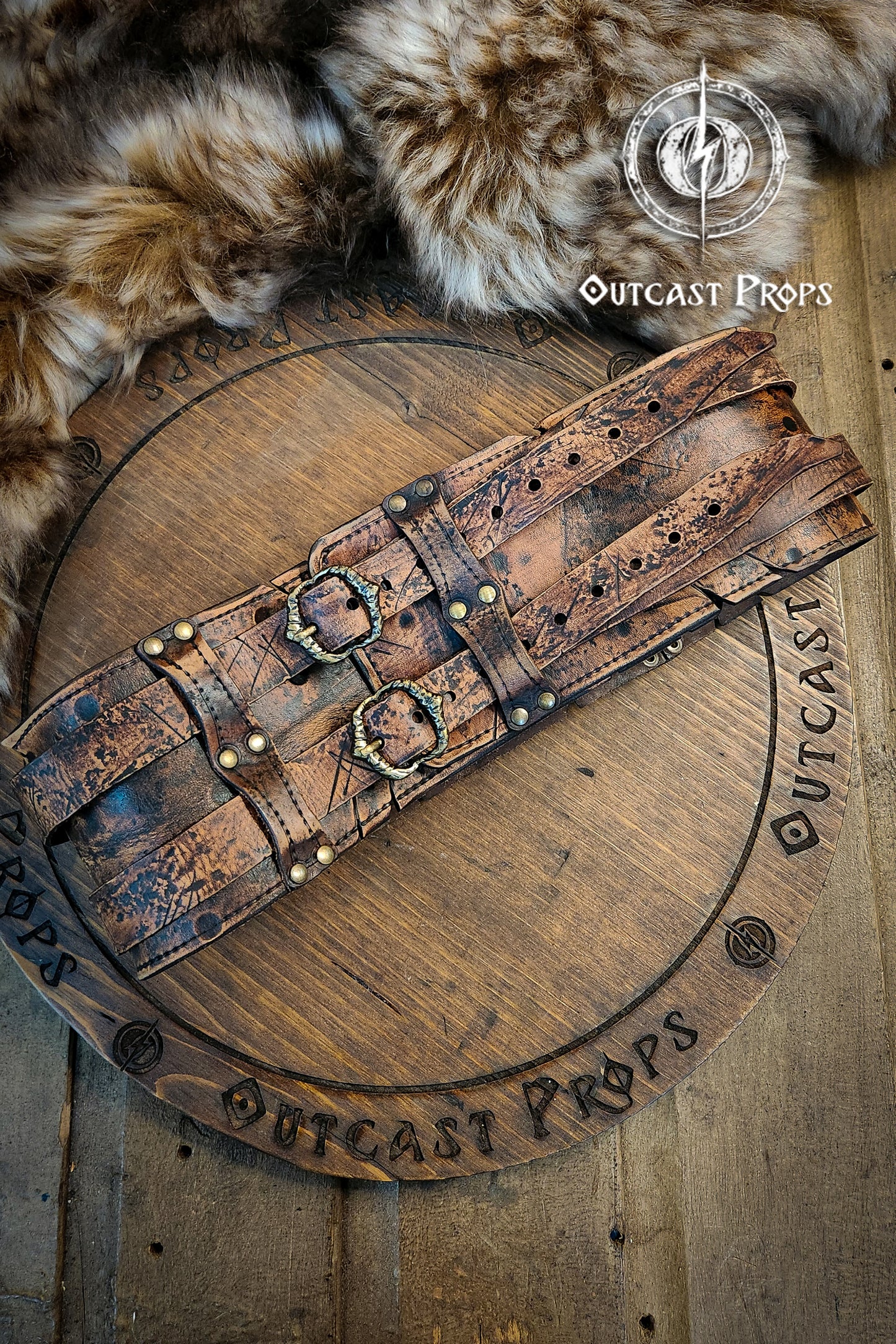 Brown doble leather broadbelt with silver buckles on a wooden surface with 'Outcast Props' branding. Veteran Leather Belt. Medieval leather belt. Orc belt. Warrior belt for larp.