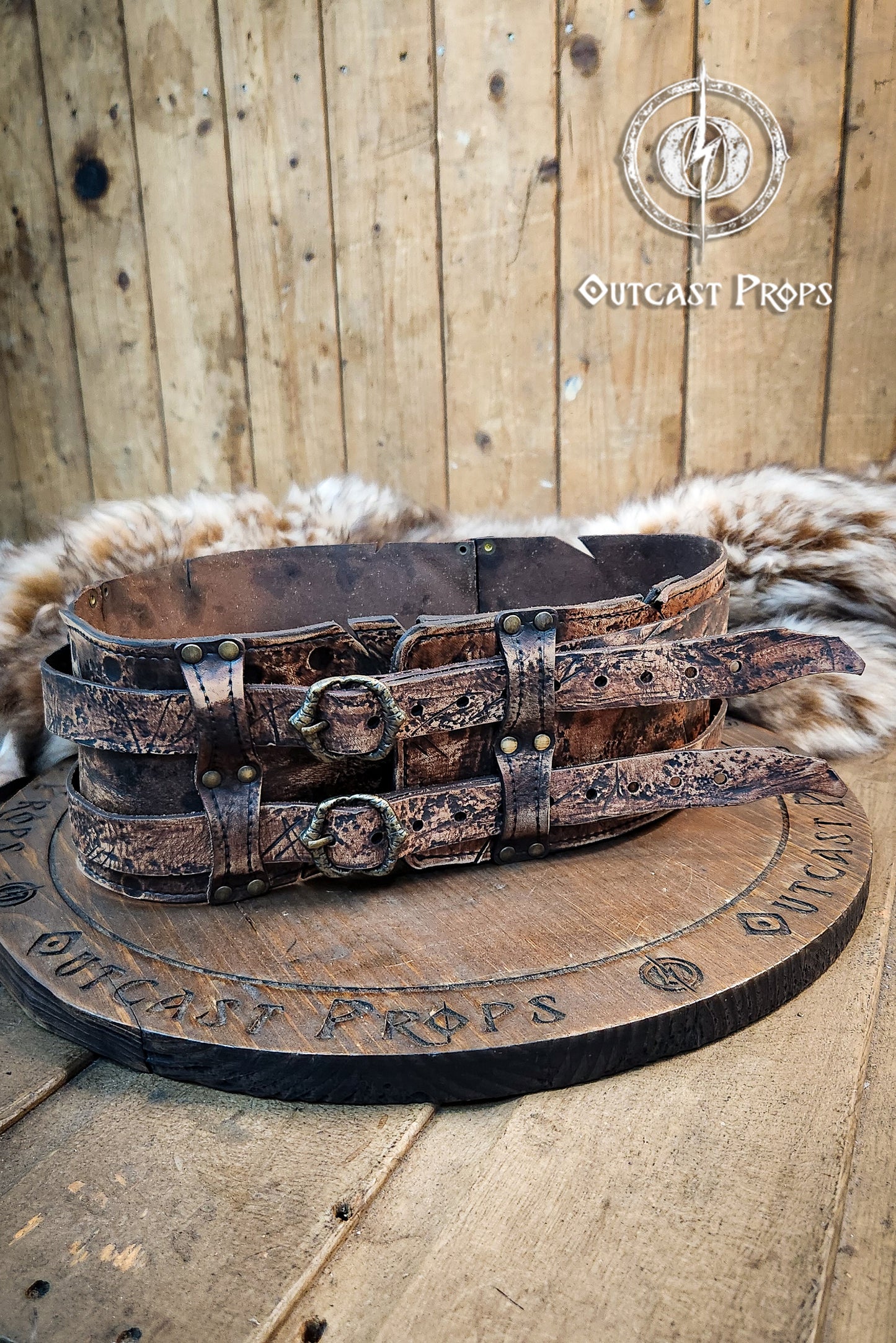 Brown doble leather broadbelt with silver buckles on a wooden surface with 'Outcast Props' branding. Veteran Leather Belt. Medieval leather belt. Orc belt. Warrior belt for larp.