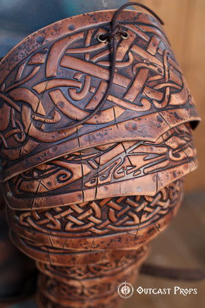 Close-up of engraved Celtic knot patterns on layered brown leather plates of the Sedrik Viking shoulder armor. High-detail view highlights the craftsmanship, aged finish, and texture of the premium leather. Designed for Viking cosplay, Celtic LARP costume, Norse warrior outfit, fantasy medieval armor, handcrafted leather pauldrons for immersive LARP and cosplay events, historical reenactment accessories with cinematic weathered look.