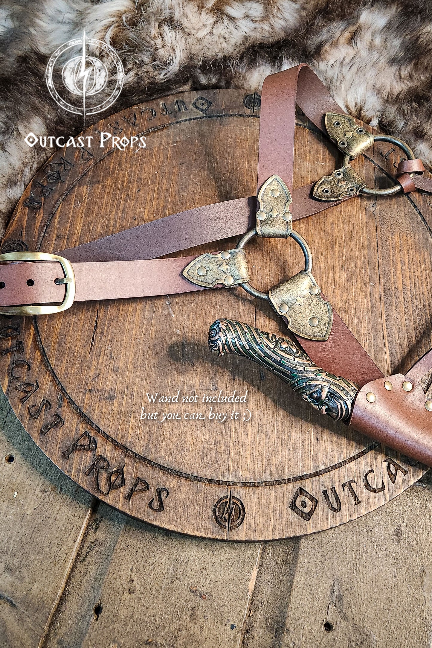 Decorative belt with brass hardware on a wooden surface with 'Outcast Props' branding.