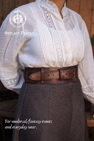 Angled front view of the Handcrafted Leather Wanderer Belt worn at the waist, showing the wide leather frame and brass buckle from a different perspective. The premium vegetable-tanned leather features visible grain, hand-finished edges, and subtle aging. A modular two-piece belt designed to suit medieval, fantasy, and LARP costumes while remaining refined enough for modern everyday wear.