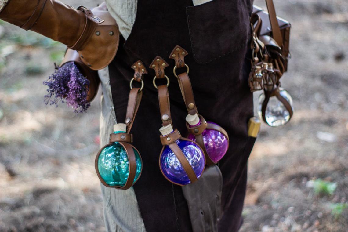 A person wearing a brown leather apron with pockets and a potion holder with glass bottles. Leather Apron, larp Alchemy steampunk crazy scientist mechanics, engineers. With accesories and pockets perfect for Barber