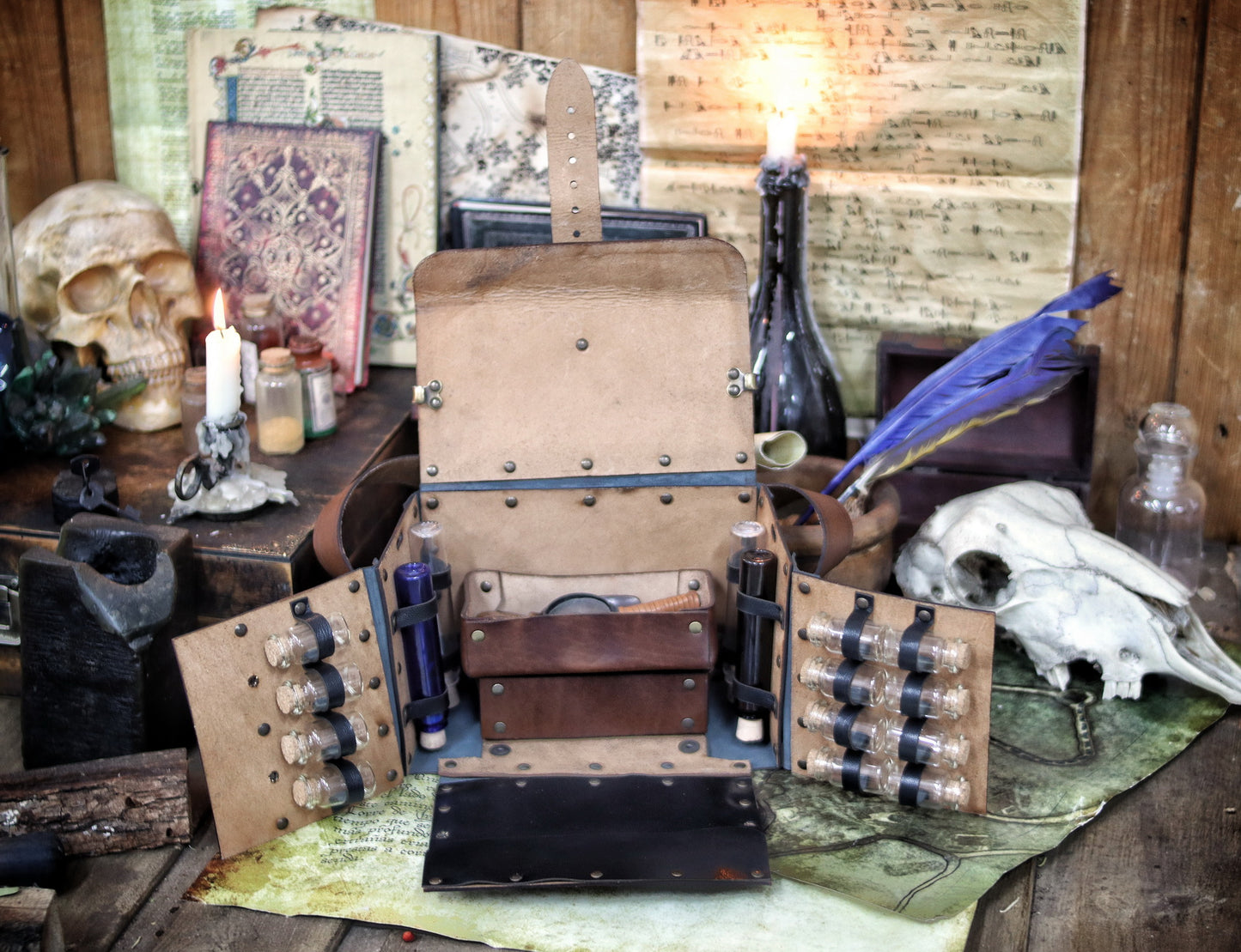 Fantasy Alchemist Bag made of natural leather, shown fully open with potion bottles, vials, and scrolls in a medieval apothecary setting. Perfect for LARP, steampunk, or cosplay characters like healers, mages, witches, or rogues. The bag includes secured compartments for bottles and a tray for tools, with quick access to emergency potions. Handmade and dyed by Outcast Props, combining practicality and immersive style for any roleplay adventure.