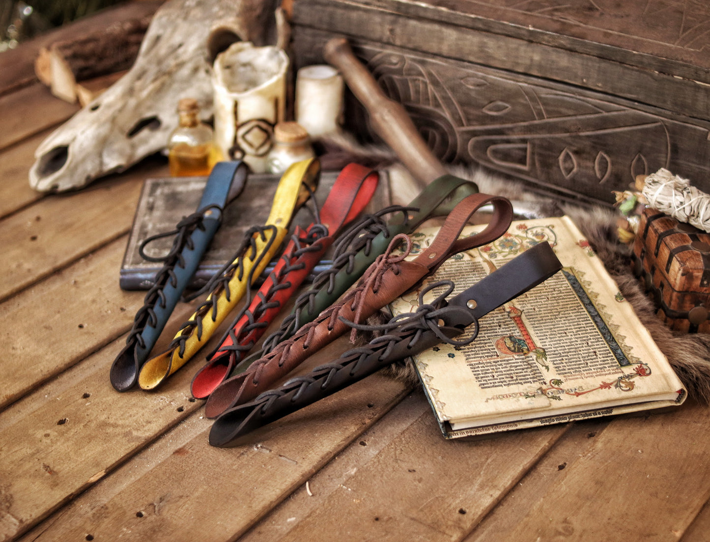 A close-up image of a brown wand holster with a leather strap and lace detail, displayed on an open book with a decorative background. Magic Wand Leather Holster Laced & Aged, perfect sheath for wizzards to hang from your belt, witch wand belt seath cosplay LARP