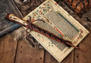 A close-up image of a brown wand holster with a leather strap and lace detail, displayed on an open book with a decorative background. Magic Wand Leather Holster Laced & Aged, perfect sheath for wizzards to hang from your belt, witch wand belt seath cosplay LARP