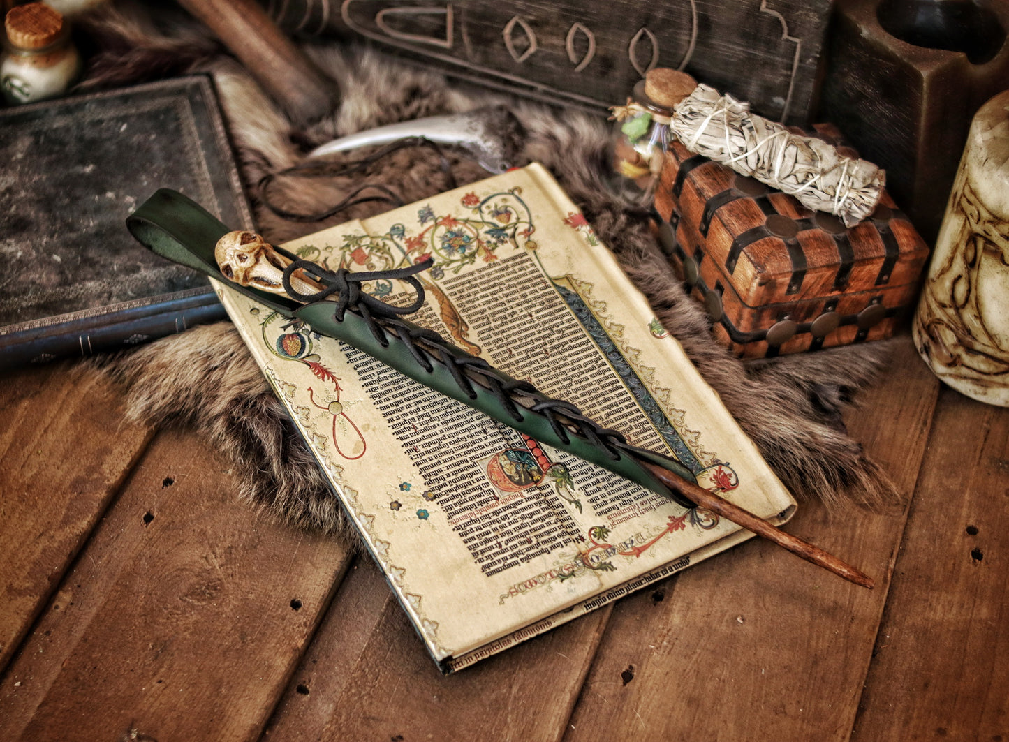 A close-up image of a brown wand holster with a leather strap and lace detail, displayed on an open book with a decorative background. Magic Wand Leather Holster Laced & Aged, perfect sheath for wizzards to hang from your belt, witch wand belt seath cosplay LARP