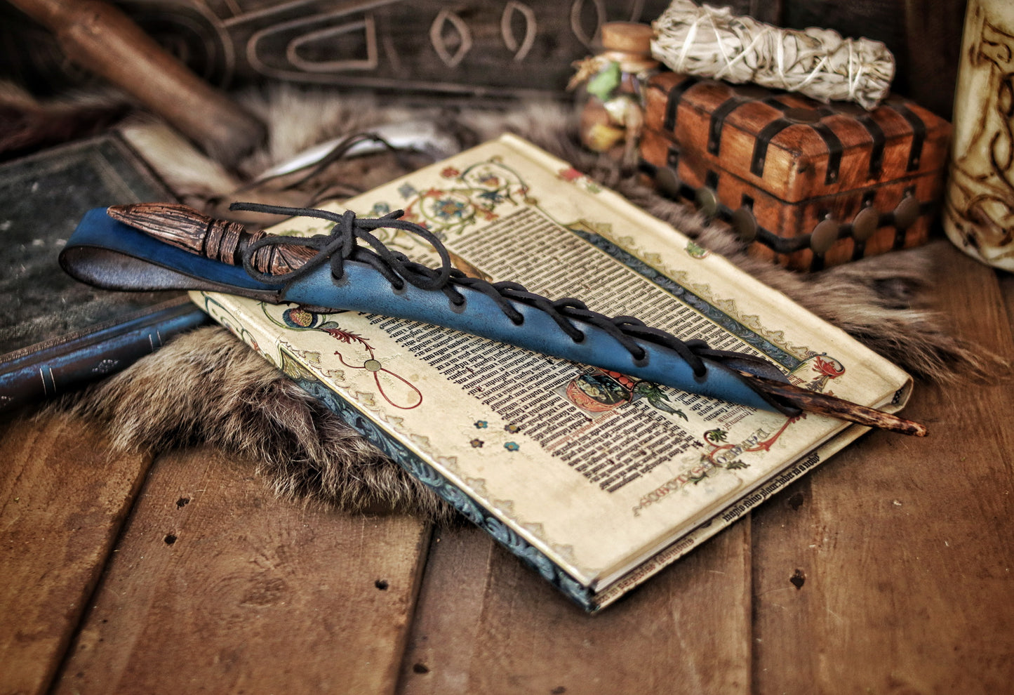 A close-up image of a brown wand holster with a leather strap and lace detail, displayed on an open book with a decorative background. Magic Wand Leather Holster Laced & Aged, perfect sheath for wizzards to hang from your belt, witch wand belt seath cosplay LARP