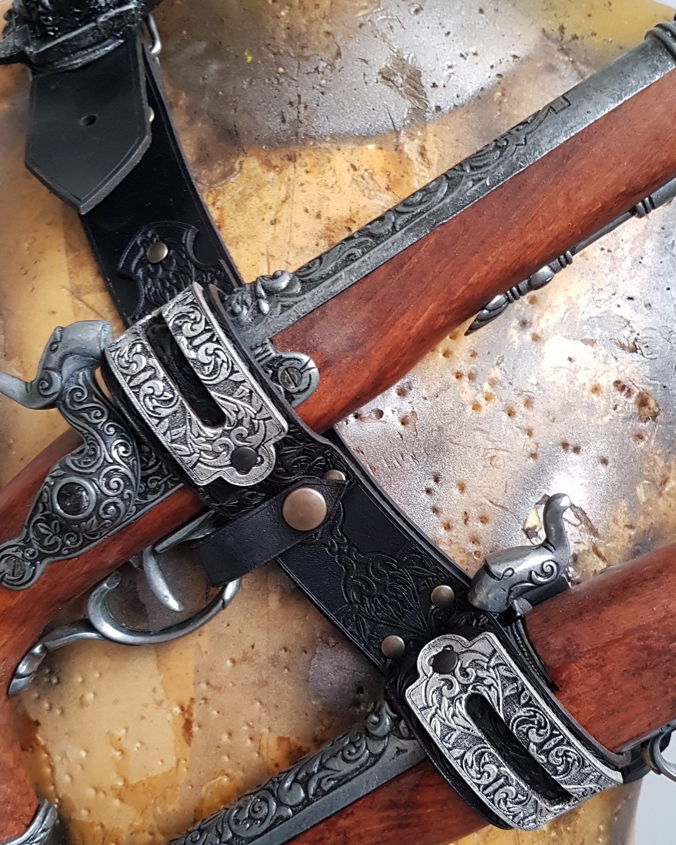 Close-up of a double leather flintlock pistol holster worn on the chest, with engraved silver buckles and dark etched leatherwork. Designed in the spirit of Edward Kenway from Assassins Creed, this pirate baldric is a stunning LARP accessory or cosplay piece. Ideal for pirate-themed costumes, fantasy events, or Caribbean rogue adventurers.