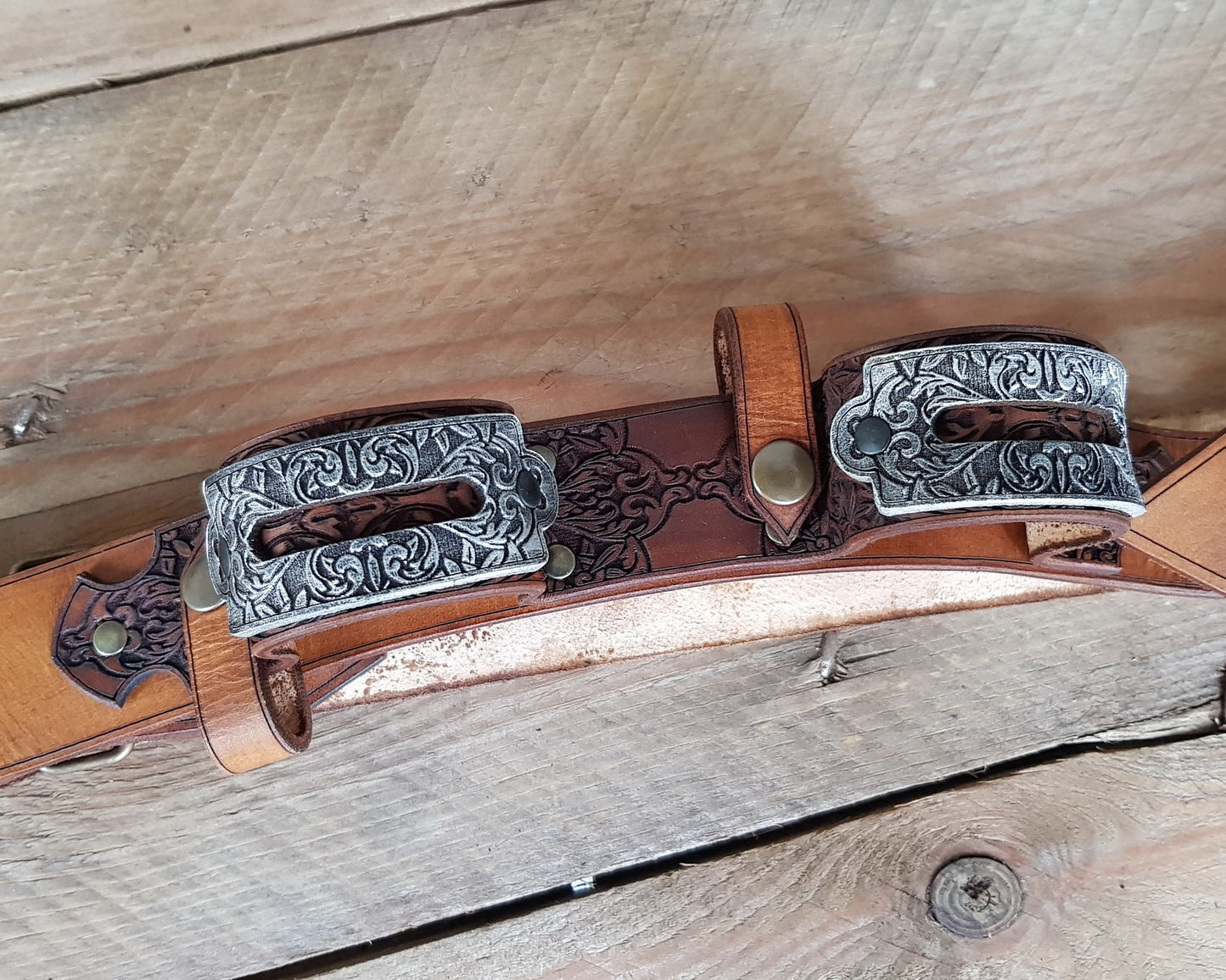 Close-up of a double leather flintlock pistol holster worn on the chest, with engraved silver buckles and dark etched leatherwork. Designed in the spirit of Edward Kenway from Assassins Creed, this pirate baldric is a stunning LARP accessory or cosplay piece. Ideal for pirate-themed costumes, fantasy events, or Caribbean rogue adventurers.