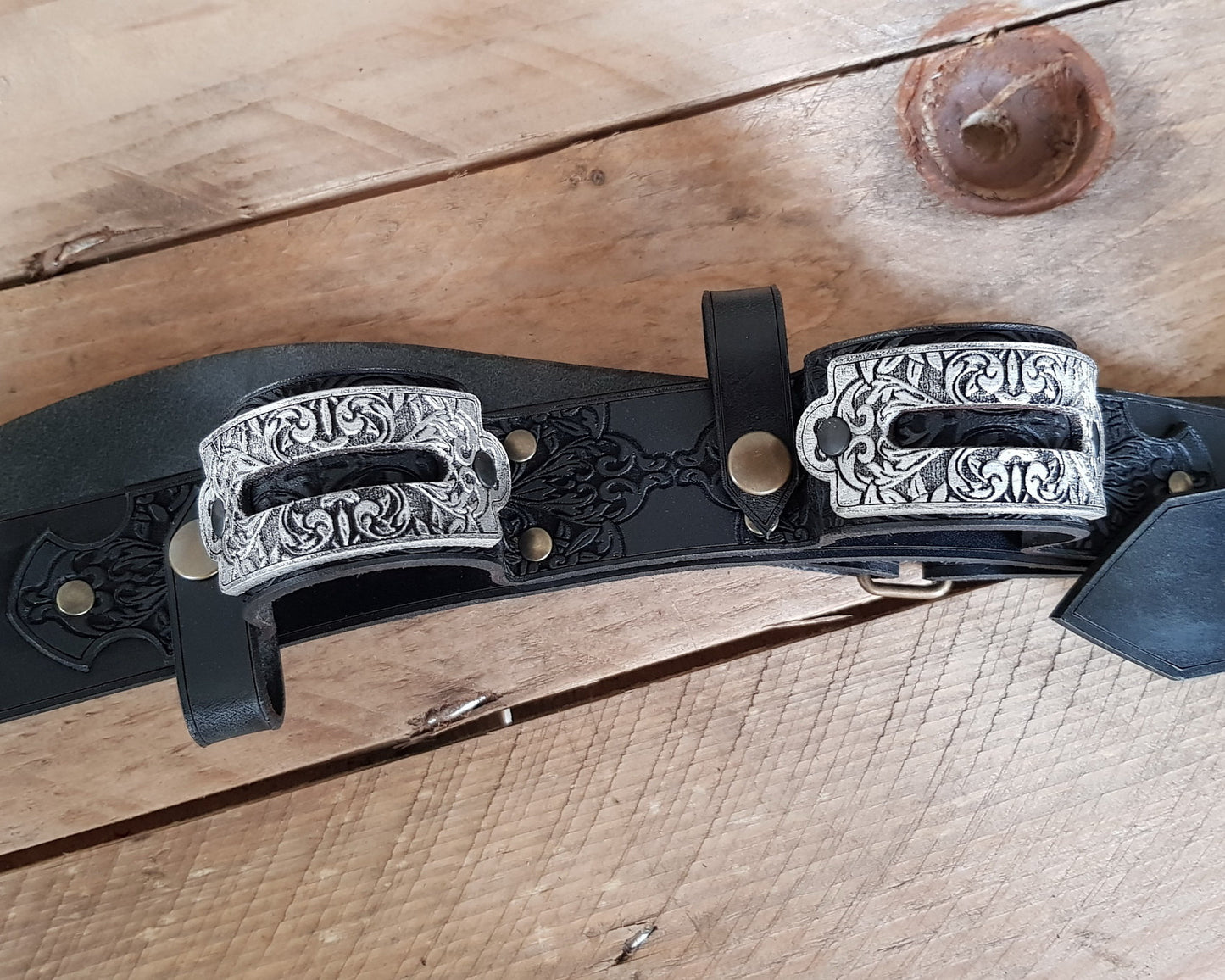 Close-up of a double leather flintlock pistol holster worn on the chest, with engraved silver buckles and dark etched leatherwork. Designed in the spirit of Edward Kenway from Assassins Creed, this pirate baldric is a stunning LARP accessory or cosplay piece. Ideal for pirate-themed costumes, fantasy events, or Caribbean rogue adventurers.
