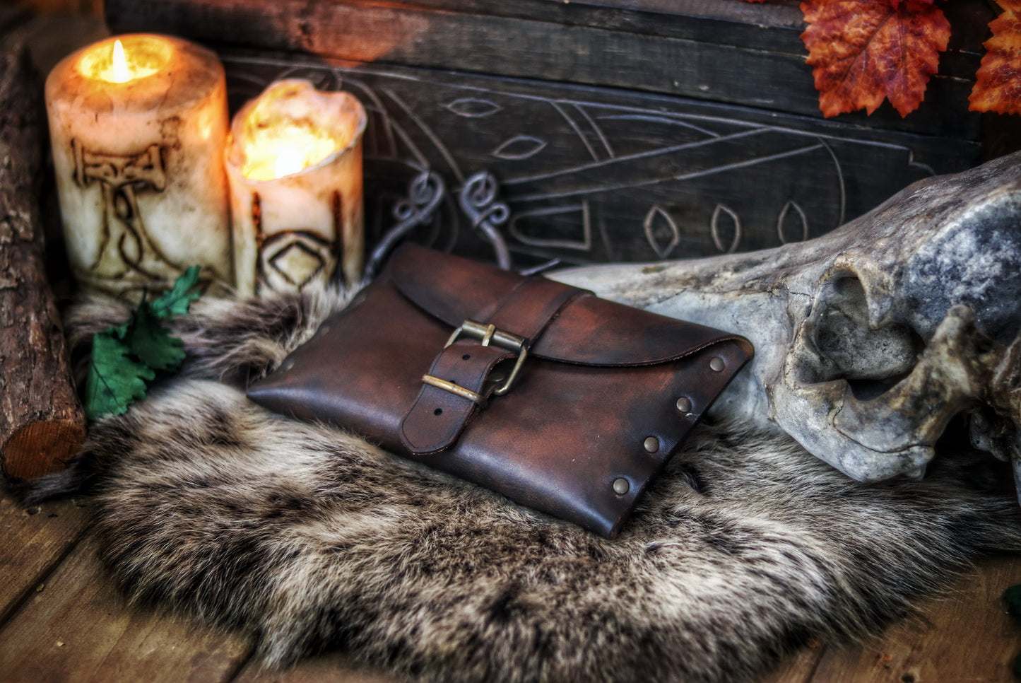 Medium brown fantasy leather belt pouch with antique brass buckle on circular wooden board engraved with Outcast Props branding. Surrounded by faux fur. Ideal for medieval scribes or LARP characters. Handcrafted pouch shows natural grain and is compatible with belts. Descriptive alt text with focus on material, use and historical style.