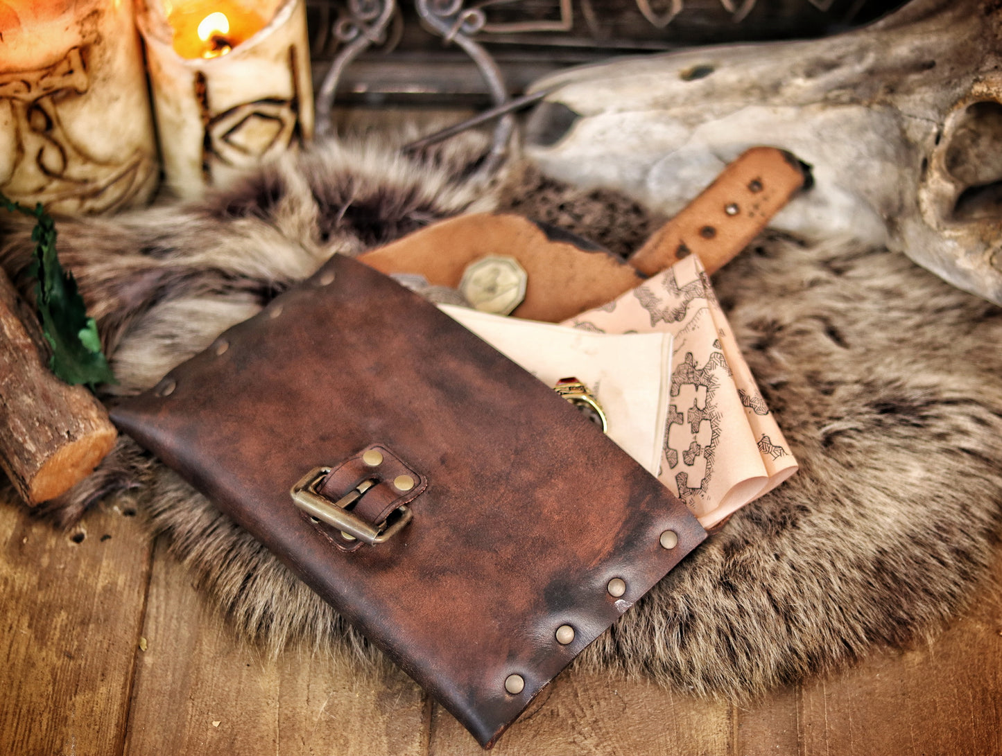 Open medieval leather pouch with brass buckle, revealing fantasy maps and scrolls inside. Ideal LARP document pouch or Renaissance fair accessory. Crafted from distressed brown leather, lying on fur with candlelight. Great for scribes, messengers, or immersive character props. Long tail optimized for handmade leather pouch with documents.