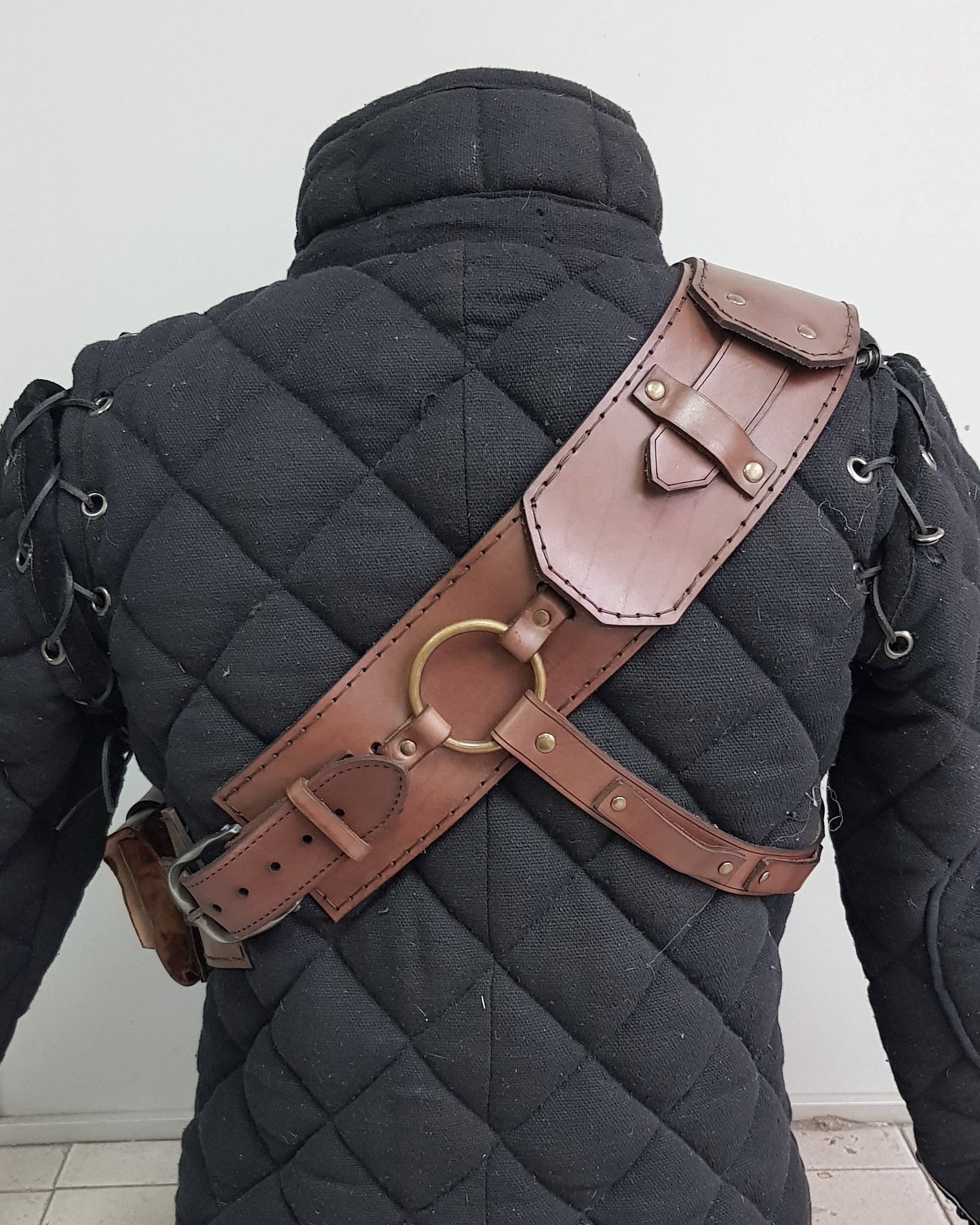 Witcher ursine armor leather baldric, back side view. Features solid stitching, adjustable straps, and iconic metal ring system. An authentic leather baldric for Witcher cosplay, Geralt LARP gear, fantasy RPGs and bear school inspired Witcher costume builds.