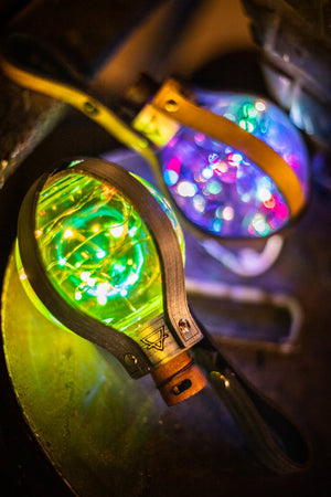 Fantasy potion bottle filled with glowing LED string lights, held by a handcrafted leather strap, ideal for steampunk costumes or science fiction roleplay. 250ml PET bottle with belt attachment, powered safely by LR44 batteries compliant with air transport regulations.
