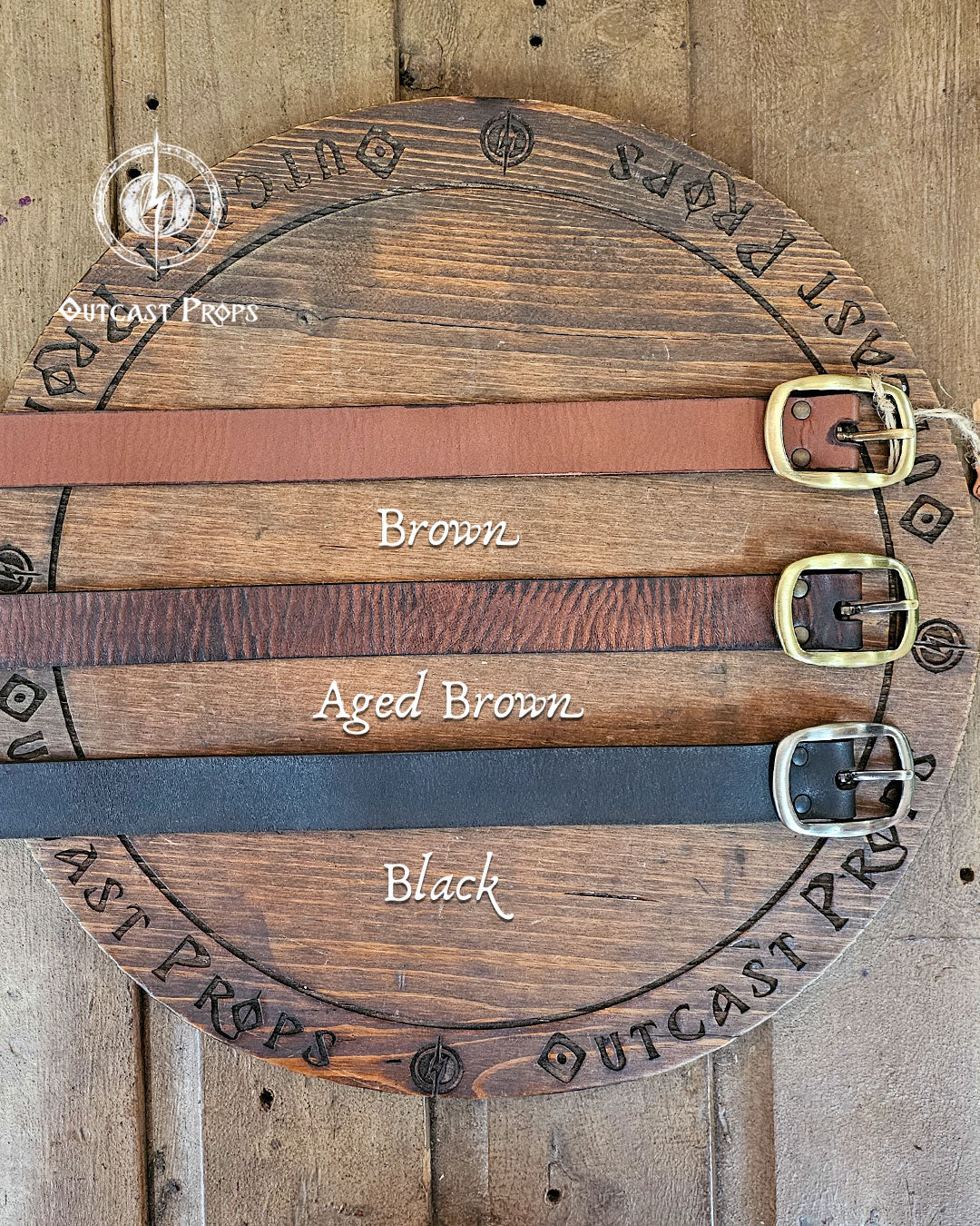 30 Plain leather belt. Wooden display with leather belts labeled 'Brown', 'Aged Brown', and 'Black' on a wooden background.