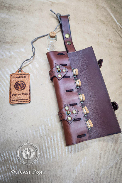 Brown leather quiver with bottle holder on a textured surface, featuring 'Outcast Props' branding. 6 Small Potion leather case, vertical belt kit for LARP, Cosplay and Costume. Easily Carry six strong cristal bottle with cork