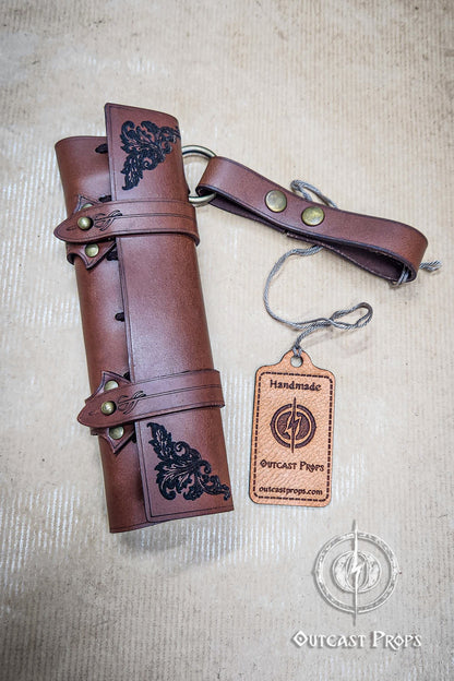 Brown leather roll with decorative elements and a matching keychain on a beige background, featuring 'Outcast Props' branding. 6 Small Potion leather case, vertical belt kit for LARP, Cosplay and Costume. Easily Carry six strong cristal bottle with cork
