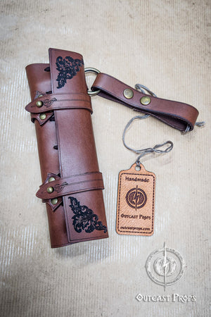 Brown leather roll with decorative elements and a matching keychain on a beige background, featuring 'Outcast Props' branding. 6 Small Potion leather case, vertical belt kit for LARP, Cosplay and Costume. Easily Carry six strong cristal bottle with cork