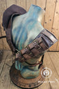 Back view of the full leather shoulder harness and double pauldron set. Sword scabbard runs diagonally from shoulder to waist. The brown leather is distressed with handcrafted aging and riveted panels. Adjustable straps and buckles allow versatile fitting. Perfect leather shoulder armor for larp viking outfit, barbarian cosplay, and post-apocalyptic costume accessories.
