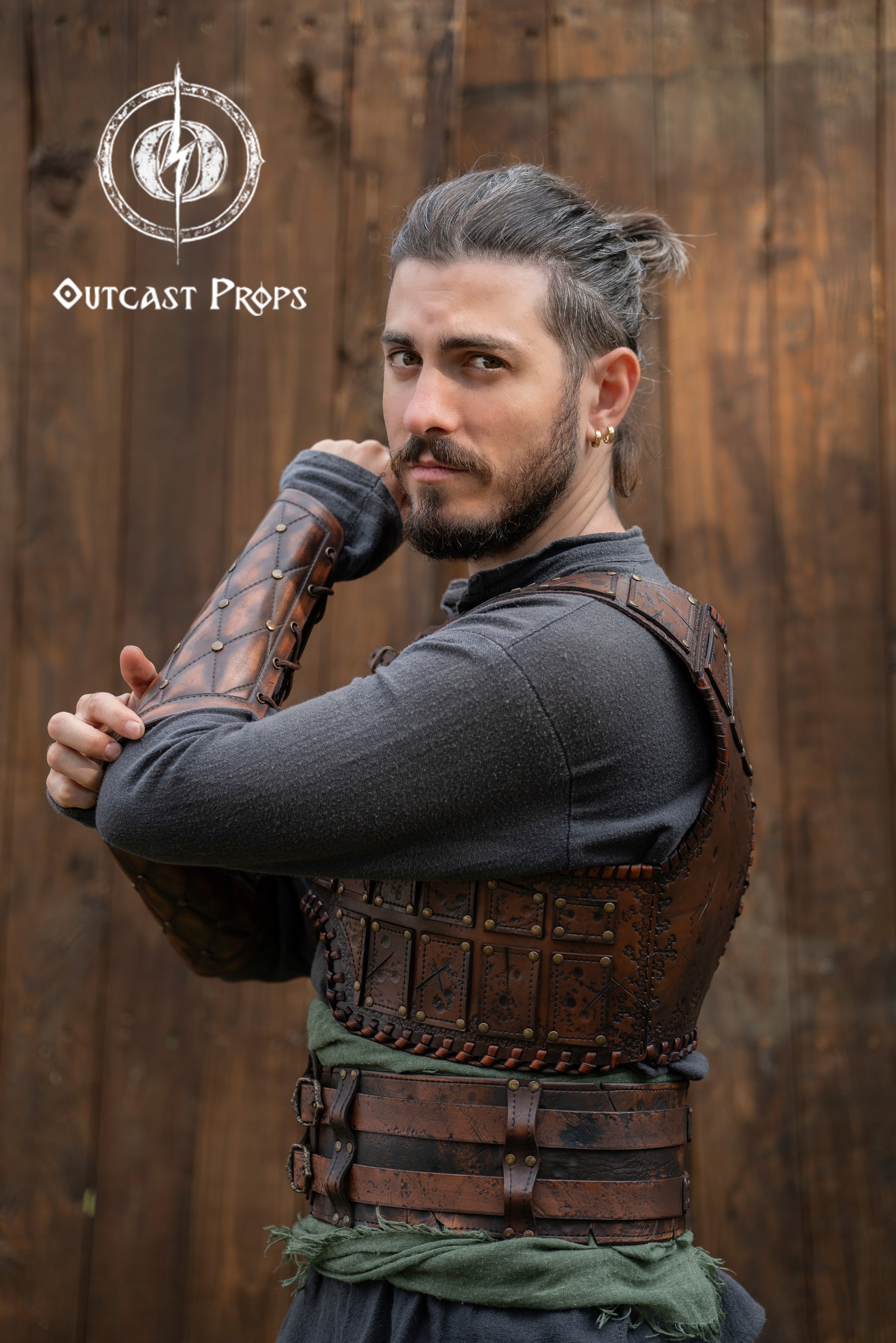 Side view of a LARP barbarian wearing a leather studded chest armor with bracers. The embossed texture and coppery rivets add realism and depth to the fantasy outfit. This warrior-style armor is ideal for Viking cosplay, fantasy conventions or immersive medieval roleplay. The aged leather finish shows Outcast Props’ handcrafted process and epic weathering techniques. Viking Studded Leather Armor Chest Armor for Men LARP Armor Witcher Leather Armour Medieval Leather Armor Cosplay Armor Fantasy Armor