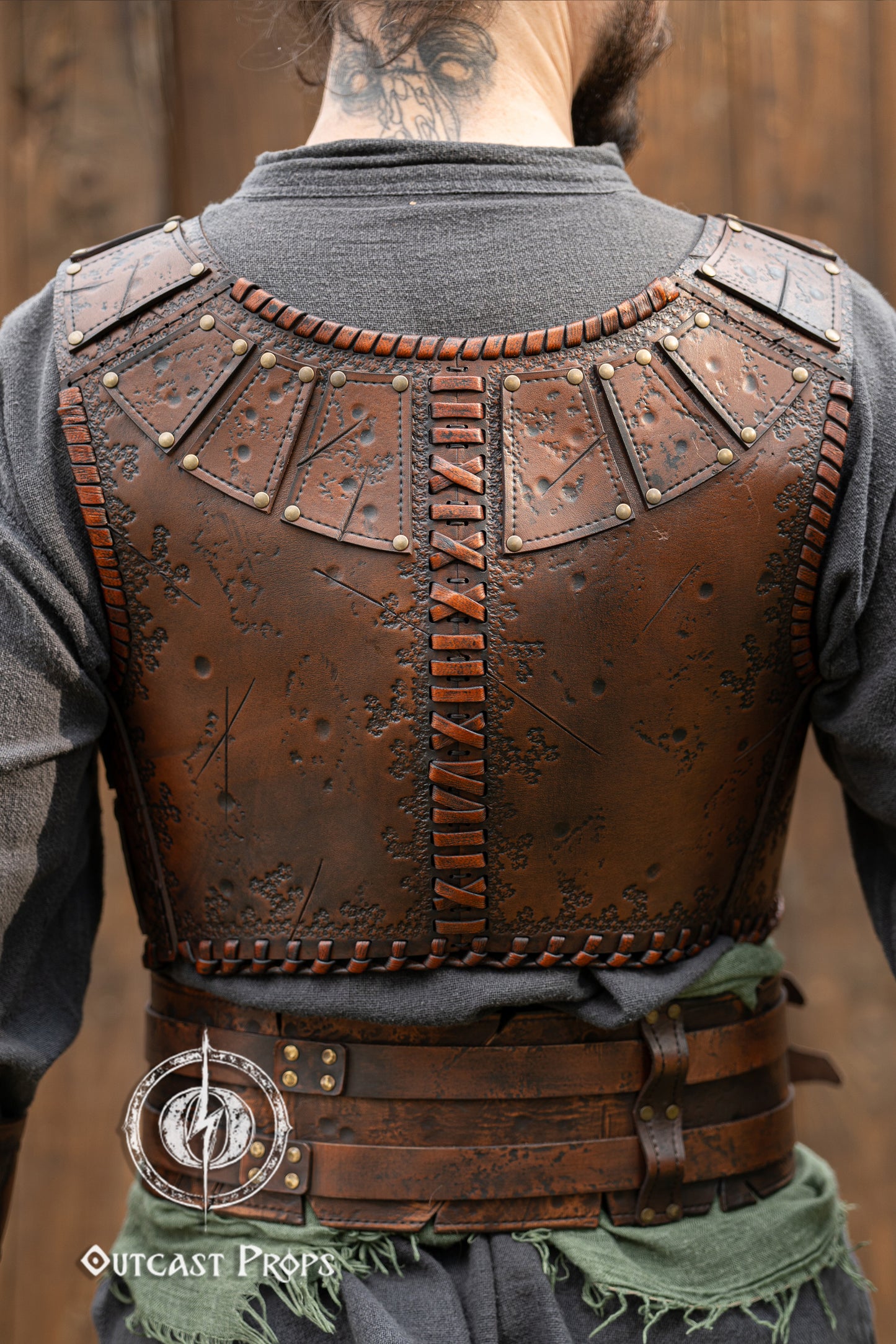 Back view of a barbarian leather armor showcasing embossed battle textures and vertical cross-stitch lacing. The segmented shoulder panels and fitted cut highlight mobility and comfort. Made from high-quality vegetable-tanned leather, this armor piece is ideal for fantasy LARP outfits, viking warriors or roleplay costumes. Features aged painting and artisanal craftsmanship by Outcast Props. Viking Studded Leather Armor Chest Armor for Men LARP Armor Witcher Leather Armour Medieval Leather Armor Cosplay