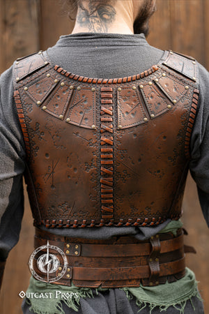 Back view of a barbarian leather armor showcasing embossed battle textures and vertical cross-stitch lacing. The segmented shoulder panels and fitted cut highlight mobility and comfort. Made from high-quality vegetable-tanned leather, this armor piece is ideal for fantasy LARP outfits, viking warriors or roleplay costumes. Features aged painting and artisanal craftsmanship by Outcast Props. Viking Studded Leather Armor Chest Armor for Men LARP Armor Witcher Leather Armour Medieval Leather Armor Cosplay