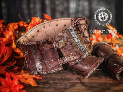 Brown leather belt with metal accents on a wooden surface with autumn leaves and blurred background. Barbarian Leather armor woman, larp armor woman viking piece woman post apocalyptic cosplay