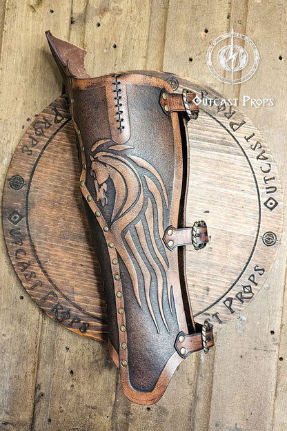 Side view of a Celtic leather greave showing the embossed horse motif inspired by the Rohirrim riders of Middle-earth. Hand-dyed aged brown full-grain leather with brass rivets and adjustable buckles, designed for LARP, Viking and medieval warriors, or mounted reenactors. Each curve and stitch highlights Outcast Props’ craftsmanship, blending Norse art, Celtic strength, and cinematic realism for horsemen and adventurers.