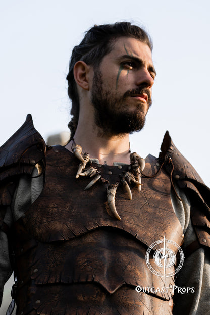 Person wearing detailed armor with a neutral background. Celtic Tusk Necklace Viking ornament Tribal Shaman Druid with realistic resin fangs Orc LARP cosplay and post-apocalypse marauder