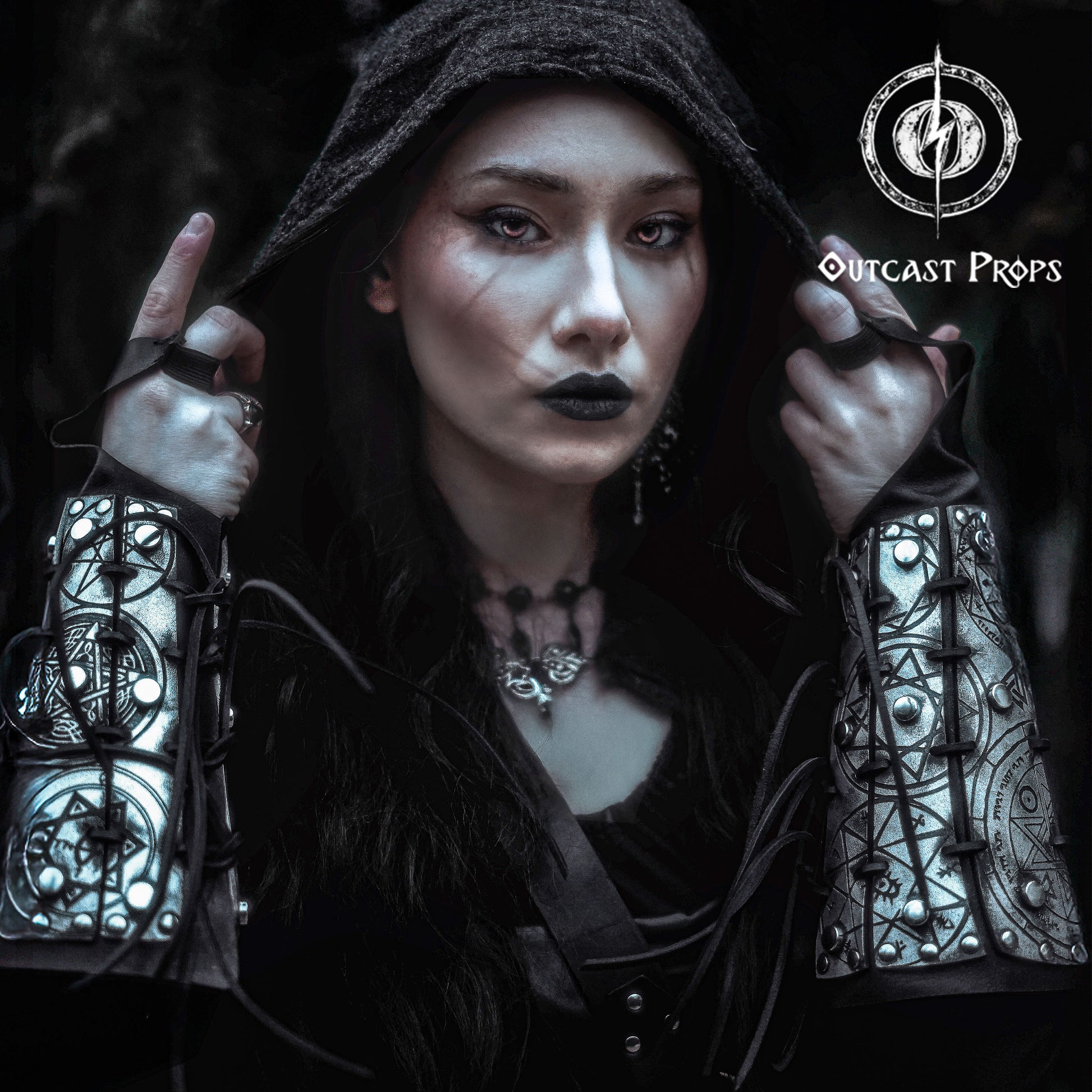Portrait of a dark sorceress wearing silver engraved bracers covered in arcane sigils and protective symbols. The bracers are laced with black cord and have a bold metallic finish. Perfect for LARP, gothic fashion, or witch cosplay. These leather bracers evoke the power of magic and the occult, designed to channel energy and dominate ritual scenes. A striking fantasy accessory for spellcasters, necromancers, or shadow mages.