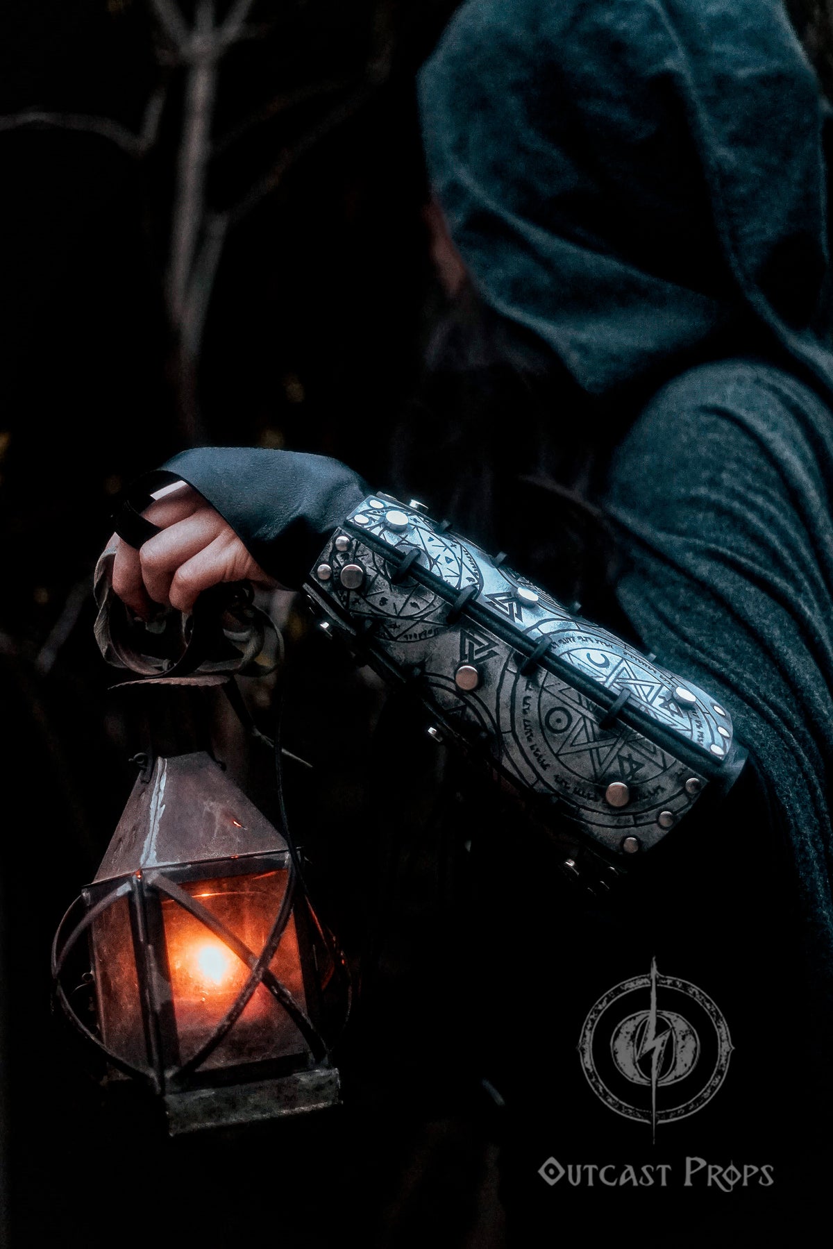 Female hand holding a lantern while wearing silver rune bracer with gothic engravings. Scene evokes mystery and magic, ideal for LARP witches, dark sorceresses, or fantasy rogues. Made with thick leather and aged painting technique, this handcrafted bracer offers full mobility, symbolic power and visual storytelling for immersive fantasy costumes.