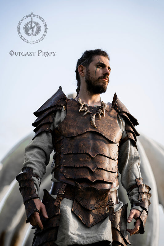 Front close-up of a man wearing the Dragon Scales Armor Set, staring into the distance with war paint under his eye. The armor’s layered leather plates, engraved and aged to look like dragon scales, evoke strength and legend. Ideal for LARP, medieval fantasy cosplay or Ren Faire, this set features handmade craftsmanship with a cinematic finish that enhances barbarian, cursed knight, or dragon hunter characters.