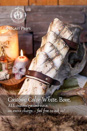 Bone-white custom version of the Dragon Scale Bracer presented on a medieval-style altar with candles and skulls. A unique accessory for necromancer LARP characters, undead warriors, or pale elven cosplays. Crafted in vegetable-tanned leather and detailed with a bone-effect finish. Fully handmade and customizable, this vambrace brings eerie presence to your fantasy gear.