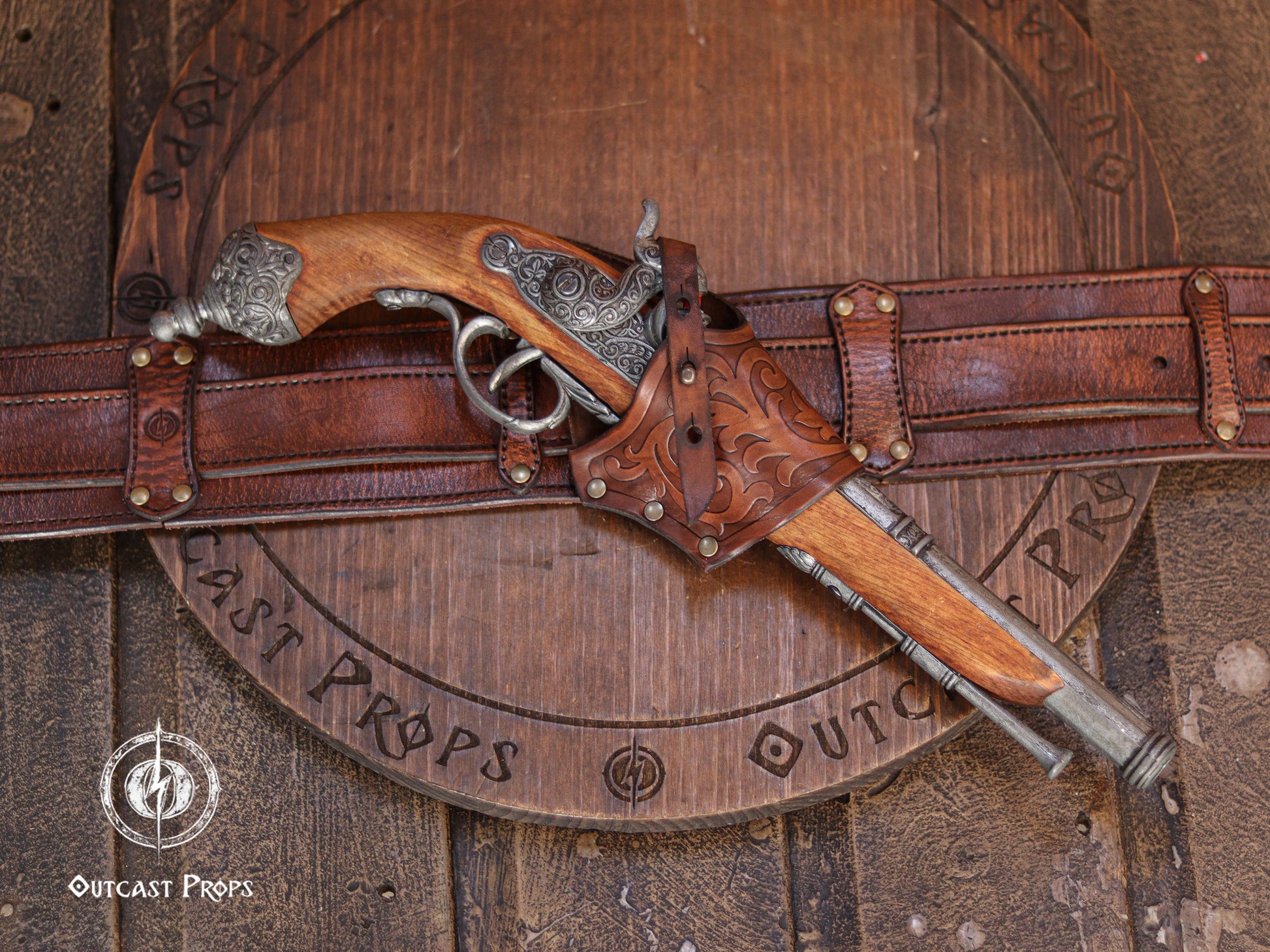 Aged brown leather flintlock holster mounted on a belt holding a pirate style flintlock pistol. Handmade leather holster with embossed tooling, brass hardware and adjustable retention strap. Designed as a cross draw holster for pirate costumes, LARP equipment, cosplay accessories and renaissance fair characters. Suitable for medium sized flintlock props while maintaining authentic historical inspired aesthetics.