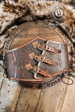 Leather underbust with embossed design and gold buckles on a wooden background. Leather Corset. Elegant underbust por cosplay and larp. Pirate corset. Pirate underbust. 