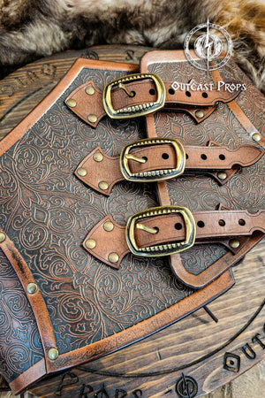 Leather underbust with embossed design and gold buckles on a wooden background. Leather Corset. Elegant underbust por cosplay and larp. Pirate corset. Pirate underbust. 