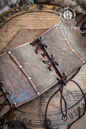 Leather underbust with embossed design and gold buckles on a wooden background. Leather Corset. Elegant underbust por cosplay and larp. Pirate corset. Pirate underbust. 
