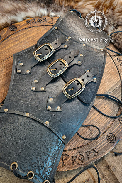 Leather underbust with embossed design and gold buckles on a wooden background. Leather Corset. Elegant underbust por cosplay and larp. Pirate corset. Pirate underbust. 