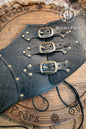 Leather underbust with embossed design and gold buckles on a wooden background. Leather Corset. Elegant underbust por cosplay and larp. Pirate corset. Pirate underbust. 