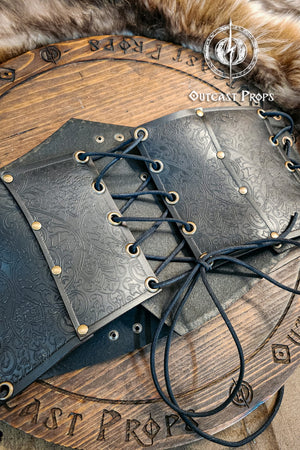 Leather underbust with embossed design and gold buckles on a wooden background. Leather Corset. Elegant underbust por cosplay and larp. Pirate corset. Pirate underbust. 