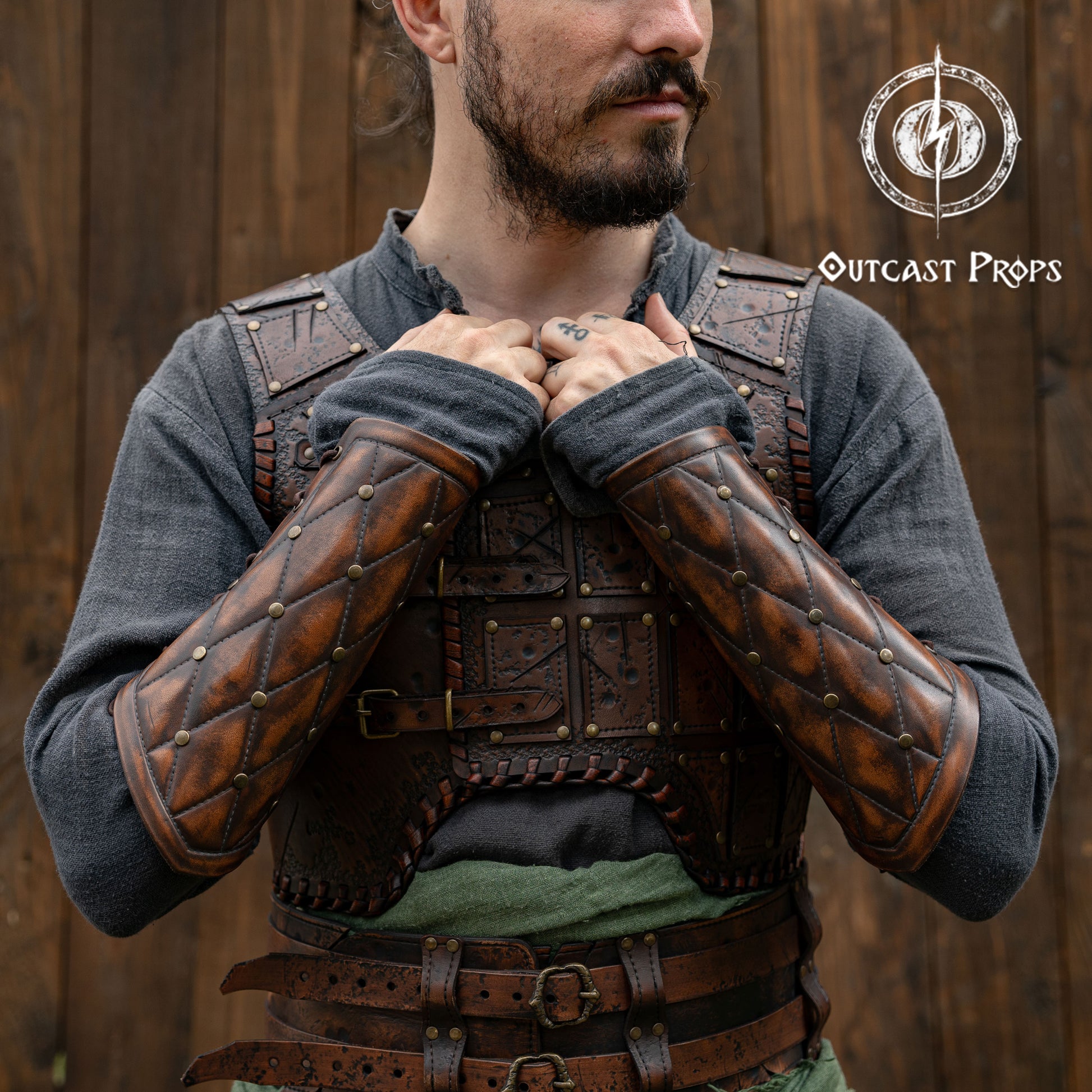 Falken leather bracers for noble costume LARP outfit medieval fantasy accessories for Ren Faire cosplay arm guards for knight character gear. Person wearing a detailed leather armor with 'Outcast Props' logo in the corner.
