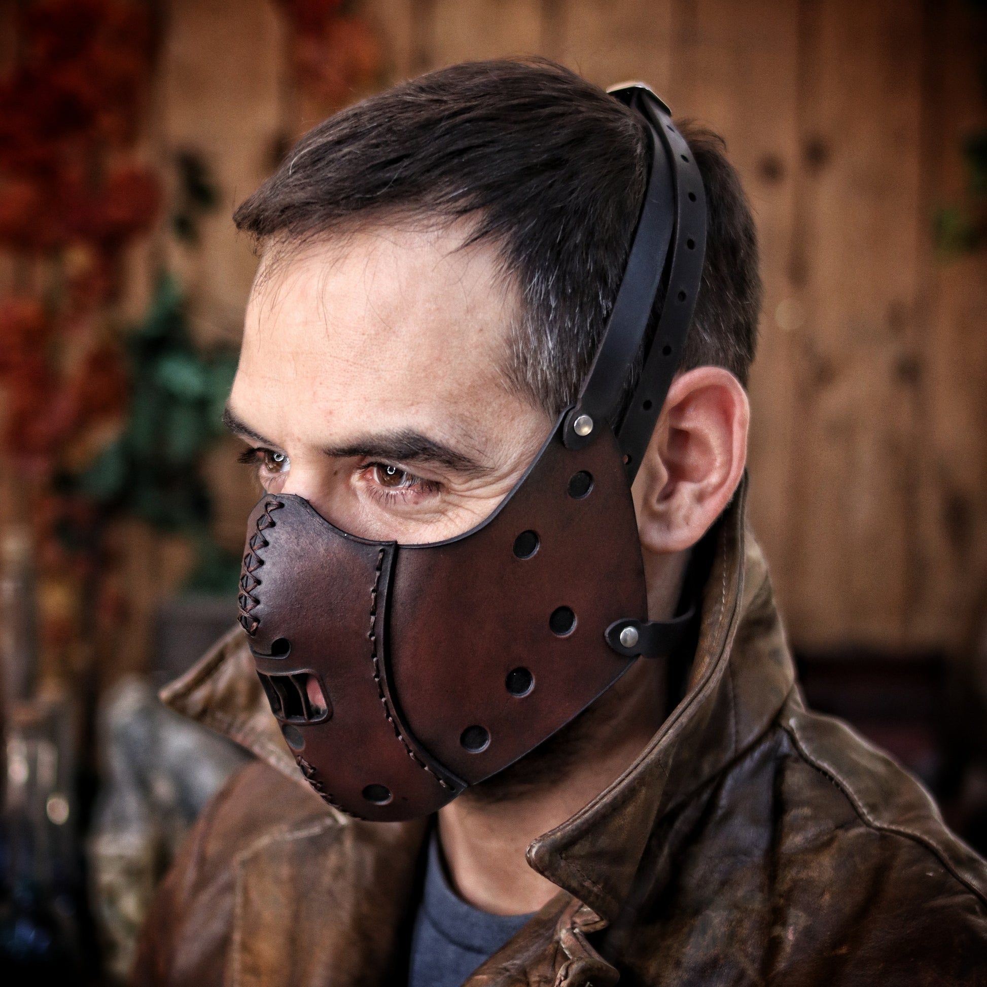 A person wearing a leather mask designed to resemble Hannibal Lecter's . Hannibal Lecter Leather Face Mask horror mask Halloween mask,human muzzle, cannibal mask, cosplay costume or larp mask.
